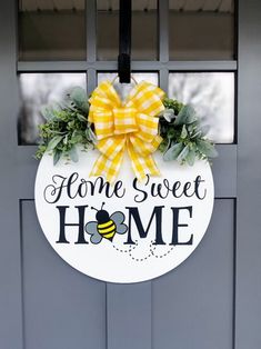 a door hanger that says home sweet home with a yellow bow on the front