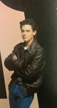 a man standing in front of a wall with his arms crossed