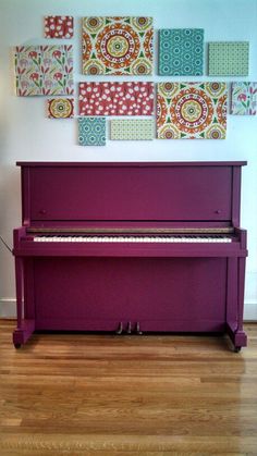 a purple piano sitting on top of a hard wood floor next to a white wall