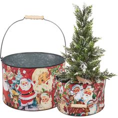 two tin pails with christmas decorations and a small tree in them, one has a santa clause on it