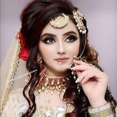 a woman wearing a bridal outfit and jewelry