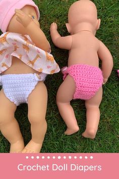 two dolls are laying on the grass next to each other and one is wearing a diaper