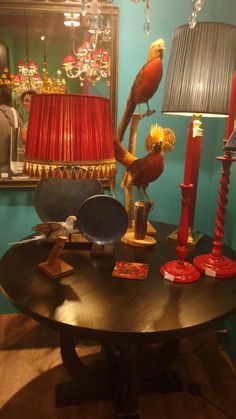 a living room with a table, lamp and bird statue on top of the table