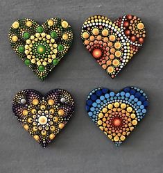 four heart shaped beaded brooches sitting on top of a table