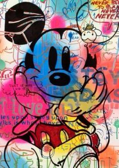 a mickey mouse painting on the side of a building with graffiti all over it's walls