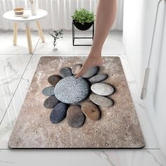 a woman's foot stepping on a rock circle rug in the middle of a room