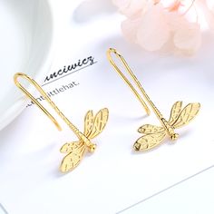 The 14K Gold Dangle Dragonfly Earrings are a stunning and unique piece of jewelry. Each earring features a delicate dragonfly charm that dangles gracefully from a 14K gold ear wire. The dragonfly charm is intricately designed with detailed wings and a long slender body. The charm is made of 14K gold, which gives it a warm, rich glow and durability. The dragonfly dangles from the ear wire, creating a subtle movement that catches the light and adds a playful touch to the earrings. These earrings a Gold Galaxy, Diamonds And Pearls, Dragonfly Charm, Gold Dangle Earrings, Citrine Earrings, Dragonfly Earrings, Ear Rings, Black Diamonds, Threader Earrings