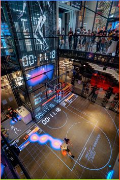 an indoor basketball court with people watching it