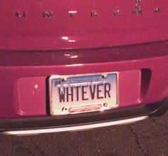 a license plate on the back of a pink car that says whatever in white letters