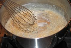 a pan with some food cooking on top of it and whisk in the middle