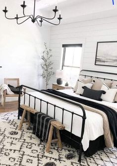 a white bedroom with black and white decor on the walls, rugs and bedding