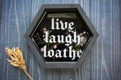 a black hexagonal box with the words live laugh love written in white on it