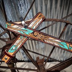 a cross made out of leather sitting on top of a metal wheel