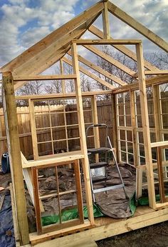 a house being built with wooden framing and windows on the roof, surrounded by construction materials