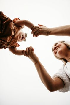 two women are holding their hands up to each other