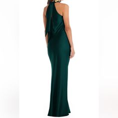 a woman in a long green dress is looking back at the camera and she has her hands on her hips