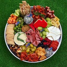 a platter filled with different types of cheeses, crackers and meats