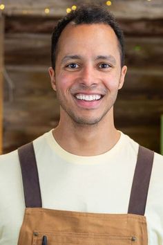 a man wearing an apron smiling at the camera