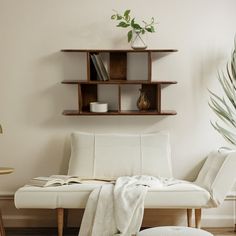 a white couch sitting next to a wooden shelf