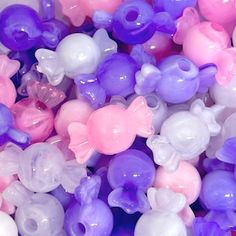 there are many different colored beads in the bowl together, including pink, purple, and white