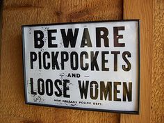 a sign that says beware pickpockes and loose women on the side of a building