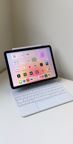 an ipad and keyboard sitting on top of a white desk