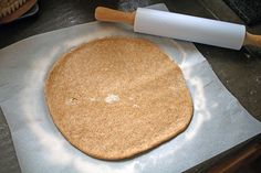 an uncooked pizza dough with a rolling pin on top