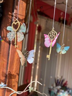 some keys are hanging from strings with butterflies on them and hearts in the air above them