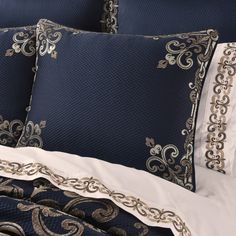 a bed with blue and white comforters and pillows