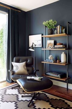 a living room with a chair, bookshelf and window