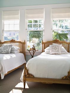 there are two beds in the room with white linens and pillows on each bed