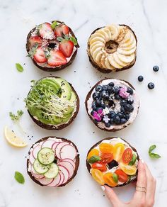 four different types of sandwiches with fruit and veggies in them on a white surface