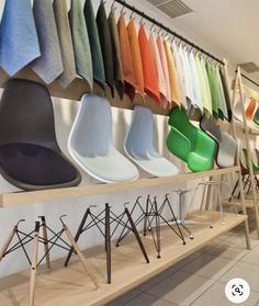 a row of chairs sitting next to each other in front of a wall filled with different colors