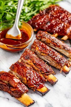 bbq ribs with barbecue sauce on the side and garnished with parsley