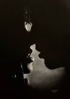 two people are kissing in the dark with their heads close to each other's faces