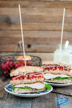 two sandwiches on plates with toothpicks in them