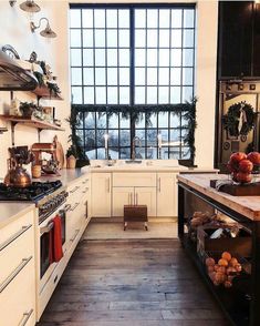 a kitchen with lots of counter space and wooden flooring next to a large window