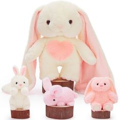 the stuffed animals are all different colors and sizes, including one white bunny with pink ears