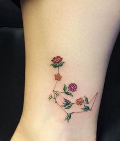 a woman's foot with a flower tattoo on the side of her leg and an arrow in the middle