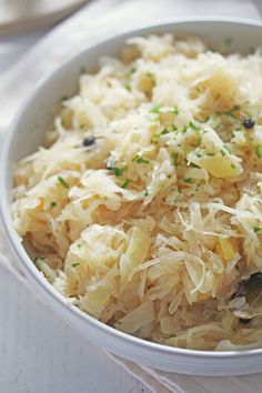 a white bowl filled with sauerkraut and topped with parmesan cheese