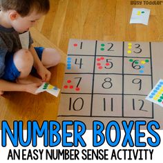 a young boy is sitting on the floor playing with numbers and counting boxes for an easy number sense activity