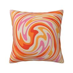 an orange and pink swirl pillow on a white background