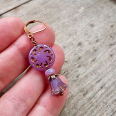 These beautiful purple earrings are sure to brighten anyone's day! These Czech glass bead compliment one another perfectly. The top bead is a 13mm purple sun wheel bead, with a bronze Picasso wash, filling in a subtle design. This is separated from the tulip bead by a 3x5 opal orange bead and a copper bead cap.The purple tulip bead has a repeat of the bronze wash on the edges of the bead, accenting the tulip shape. These earrings are also available with antique brass. Happy to put a titanium ear Handmade Purple Drop Clip-on Earrings, Single Purple Drop Earring, Purple Single Drop Earring, Adjustable Purple Jewelry With Lever Back Ear Wires, Lavender Pierced Earrings For Gift, Purple Bohemian Flower Earrings For Gift, Purple Bohemian Flower Earrings As Gift, Bohemian Purple Flower Earrings For Gifts, Purple Flower-shaped Pierced Earrings