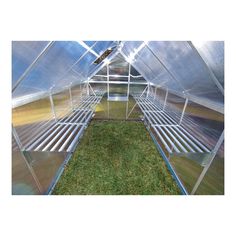 the inside of a greenhouse with grass growing in it and metal slats on the sides