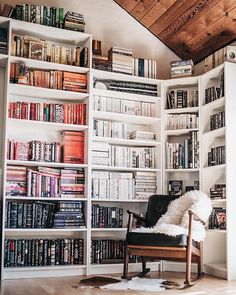 a chair in front of a book shelf filled with books