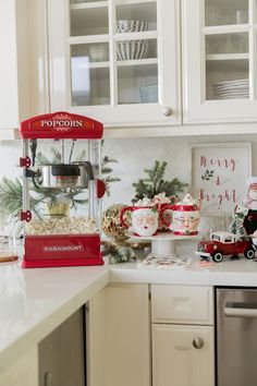 a red popcorn machine sitting on top of a kitchen counter next to a christmas tree