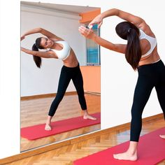 a woman doing yoga poses in front of a mirror