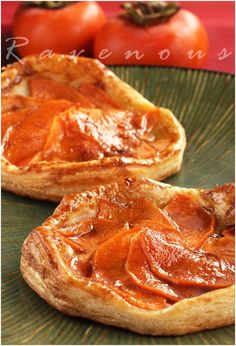 two pieces of bread on a green plate with tomatoes in the backgroung