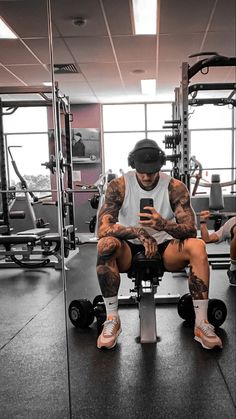 a man sitting on top of a bench in a gym