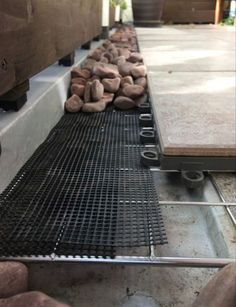 there are rocks laying on the ground next to each other in front of a metal grate